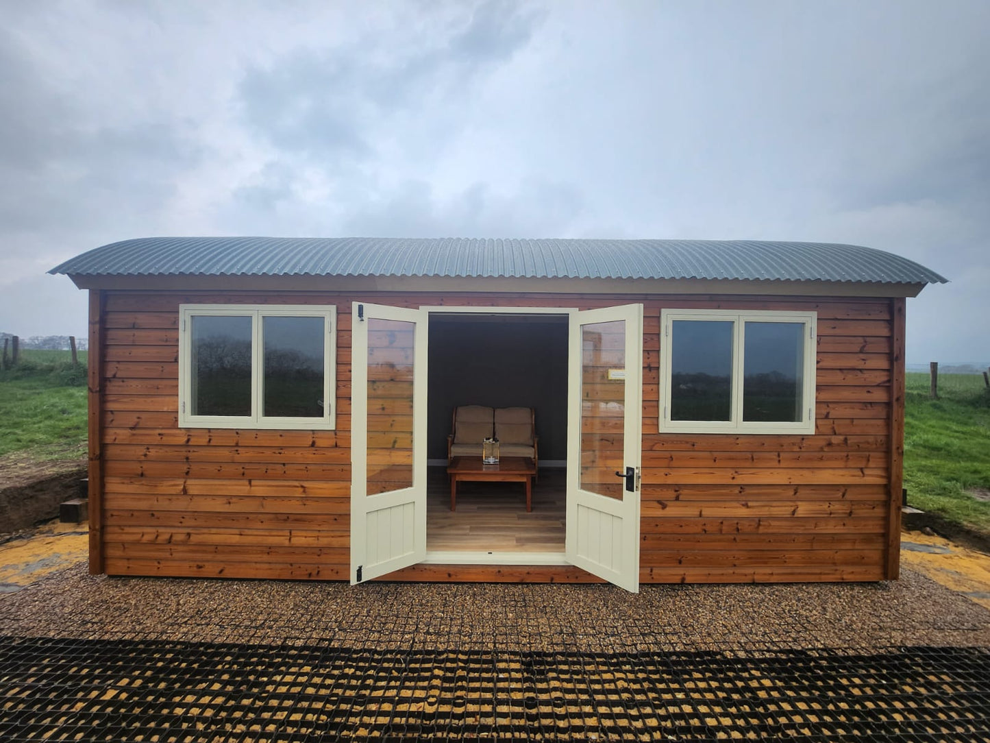 Extra-large shepherd hut with wooden cladding, double windows and double doors.