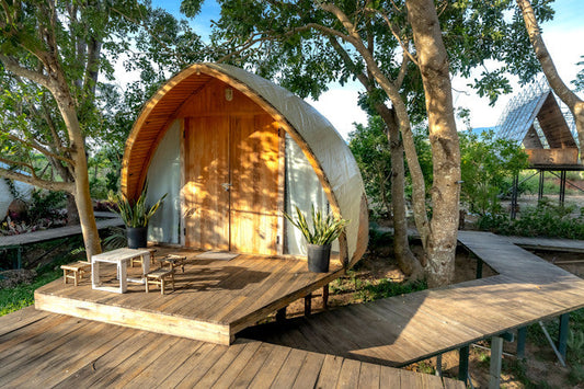 Exterior of a glamping pod with a wooden deck and walkway.