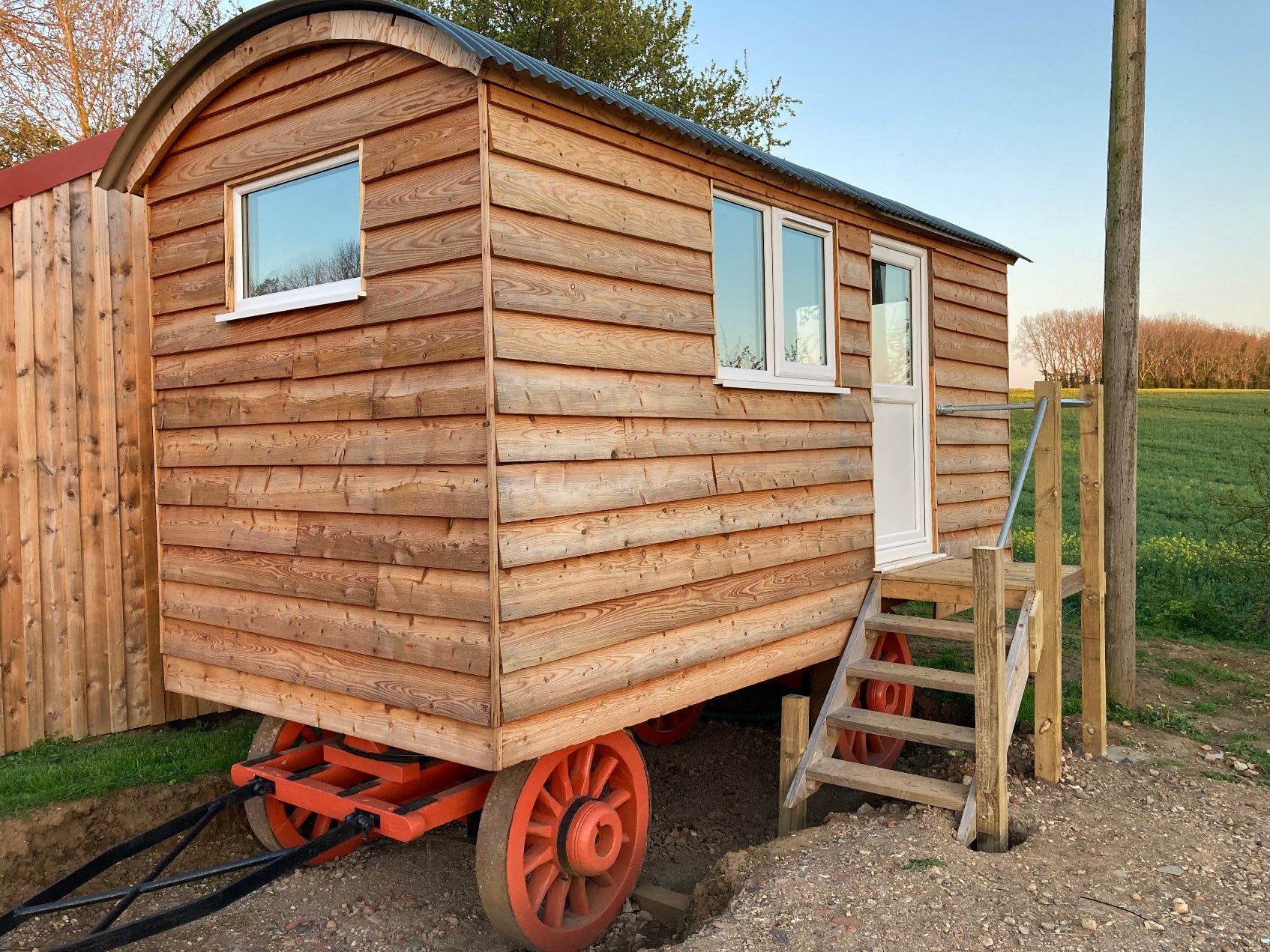 Wooden shepherd hut with small double casement window.