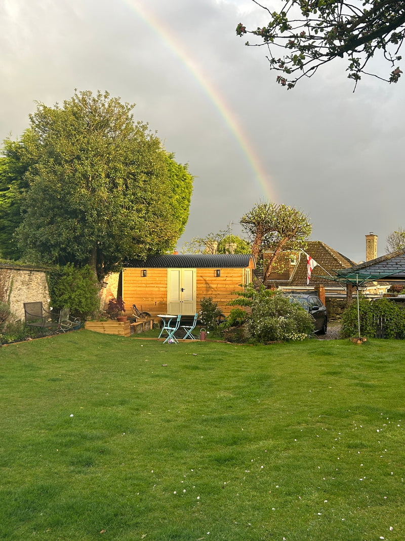 XXL Shepherd Hut self-build kit featuring a spacious wooden structure with large French doors in garden.